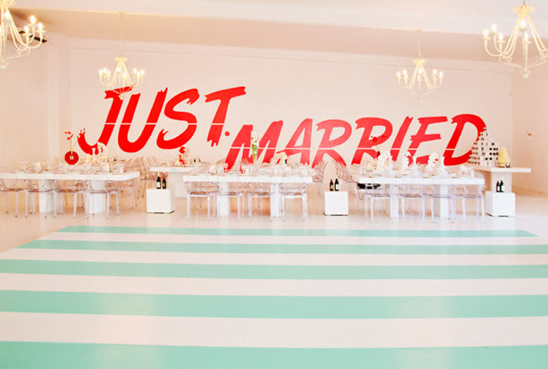 peach room with green striped that says "just married" on the wall