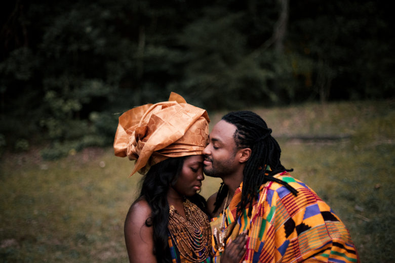 Couple wearing brightly colored clothes embracing in field