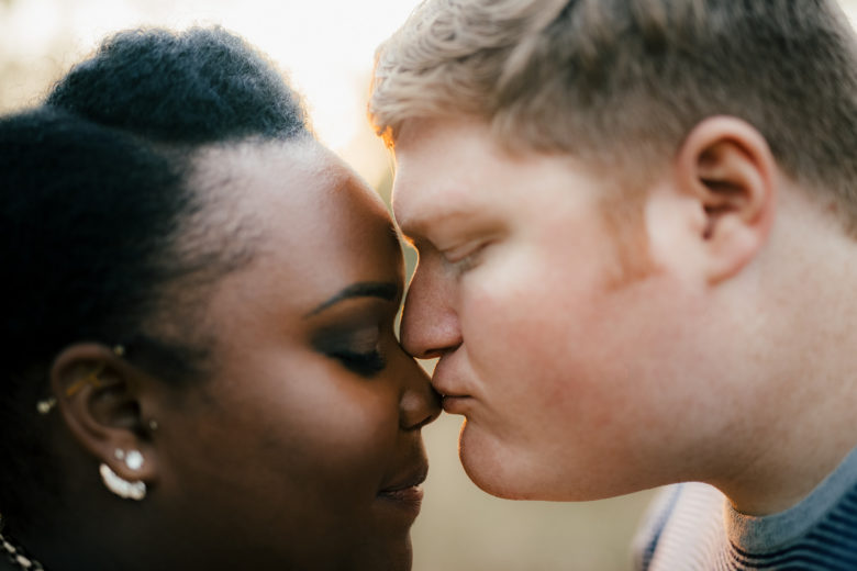 Portrait of a mixed-race couple, man kissing woman on the nose