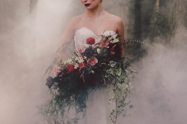 Bride holds a massive bouquet as she is enveloped in smoke