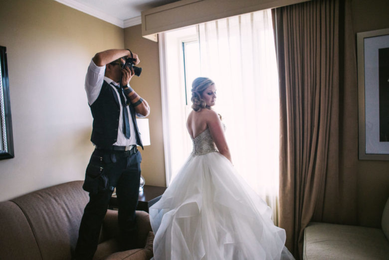 An amazingly handsome wedding photographer is being heroic and doing his job