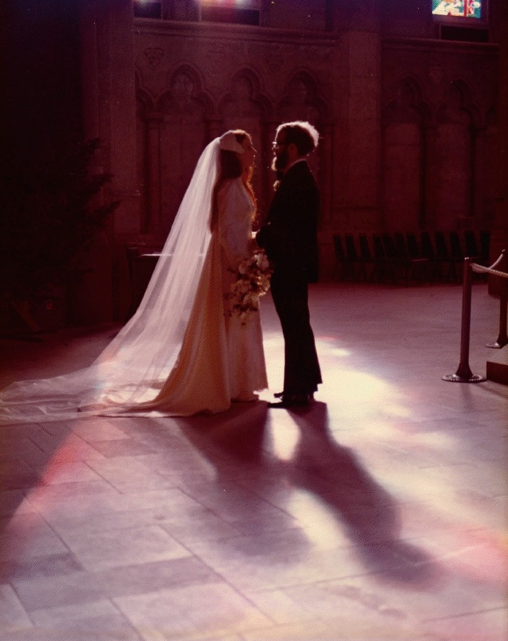 A wedding couple stand quietly in a church
