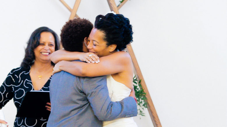 Black couple hugging at end of wedding ceremony