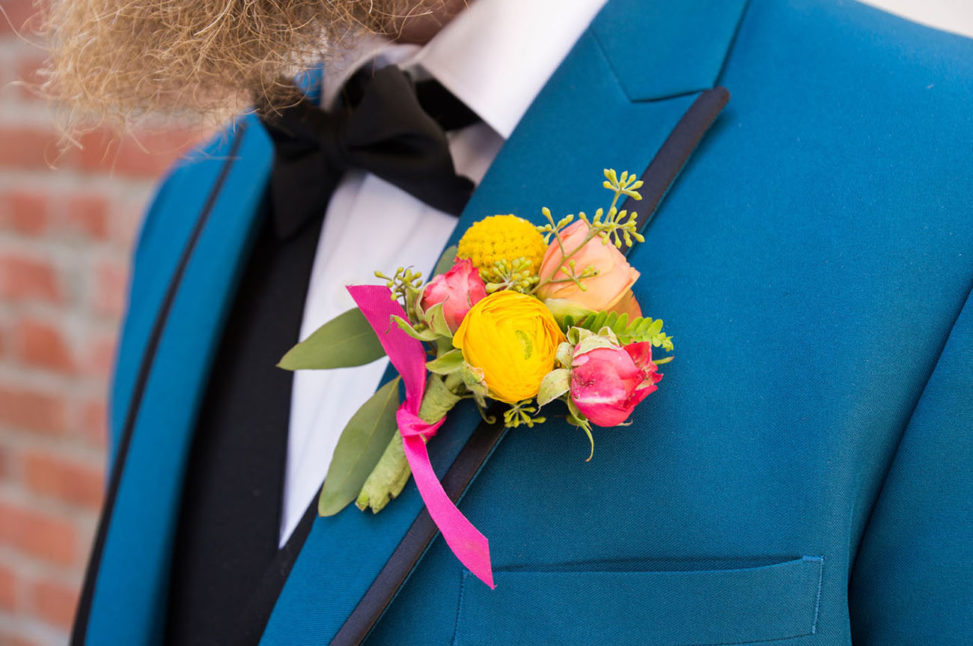groom with bright blue suit and yellow and pink boutenniere