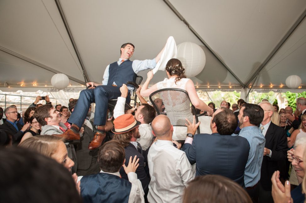 bride and groom lifted on chairs during horah