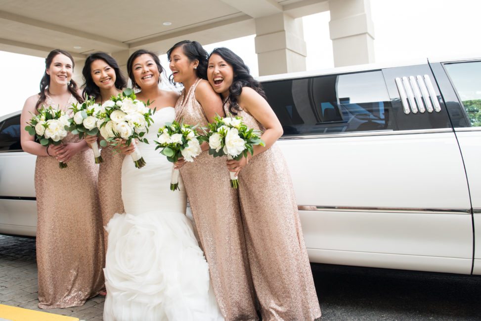bride with four bridesmaids in pink sequined dresses in front of white limo