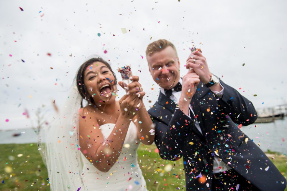 bride and groom shooting confetti poppers and laughing