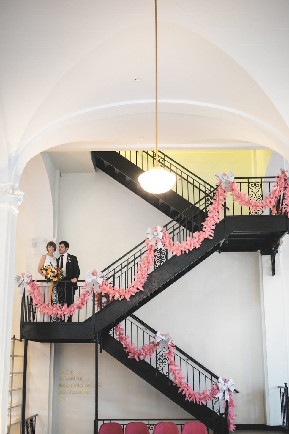 couple standing on stairs with steamer on the railing