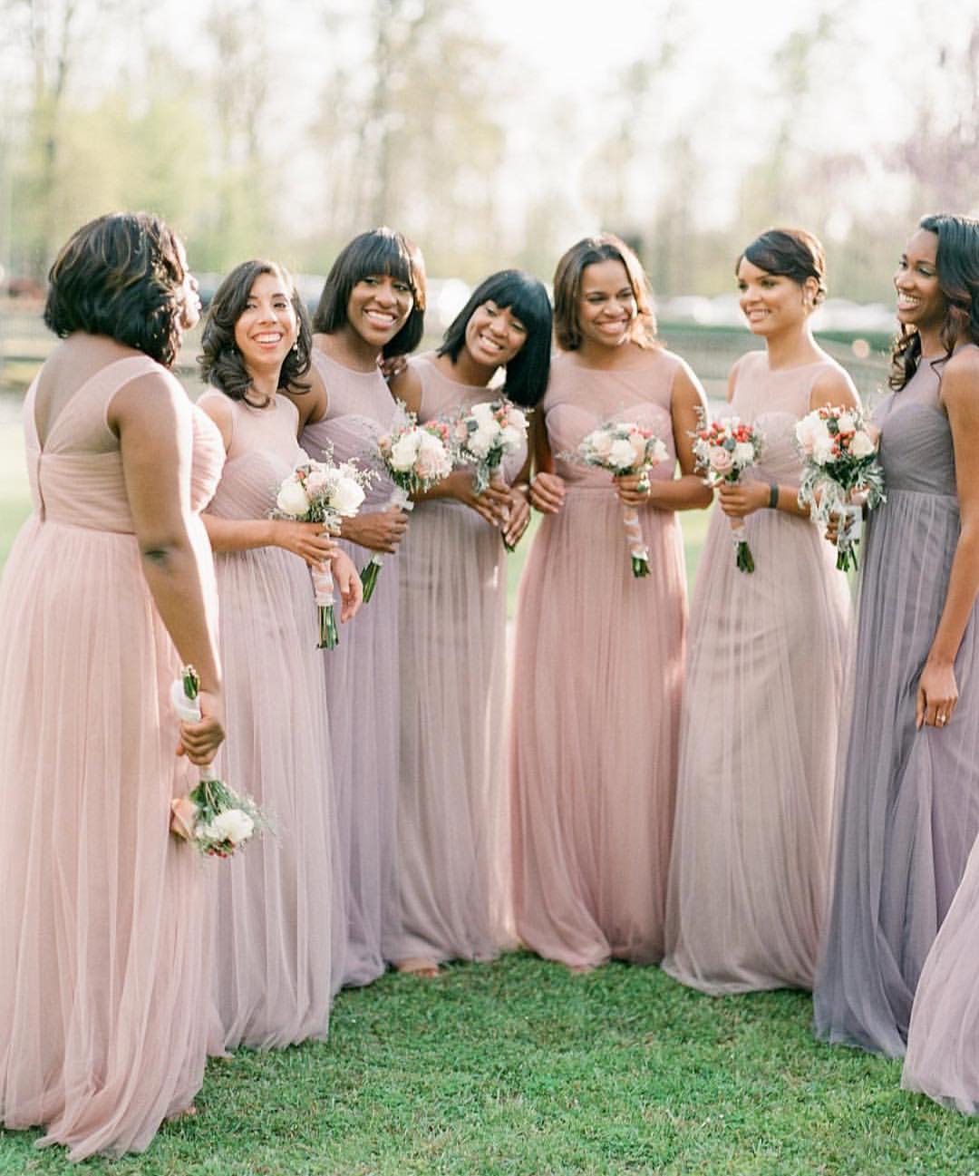 bridesmaids wearing mismatched bridesmaid dresses in a combination of light purple and mauve and blush