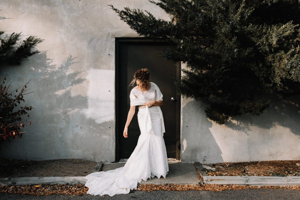 a bride looks downward as her dress train is in the gutter