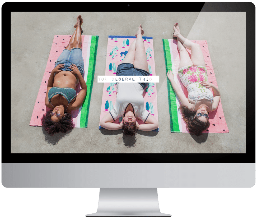 Three women laying out in the sun on beach towels