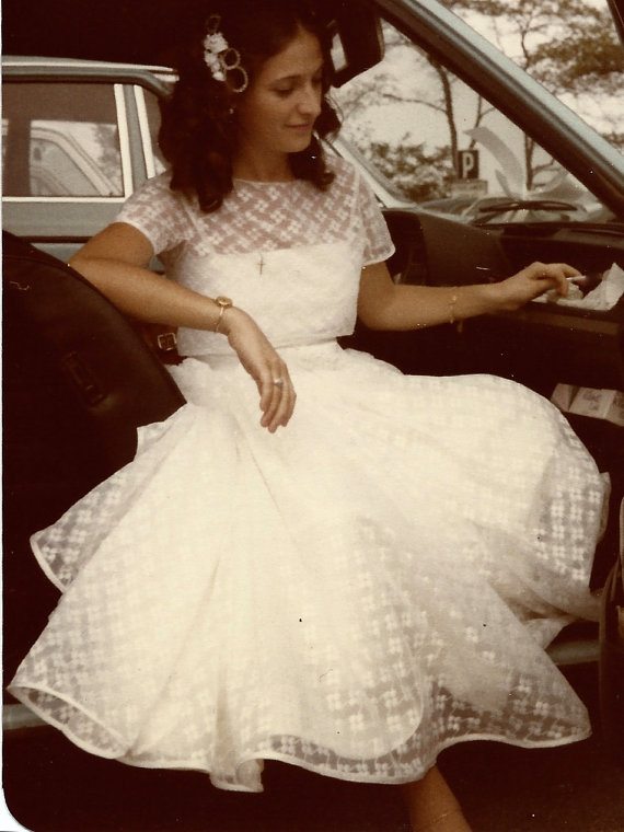 vintage picture of a woman wearing a dress in a car