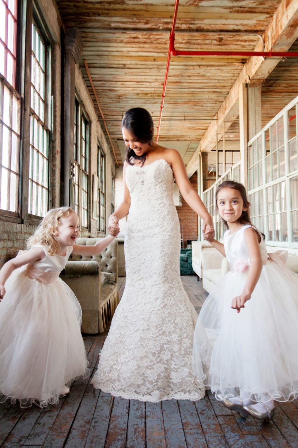 a bride dances with her flower girls