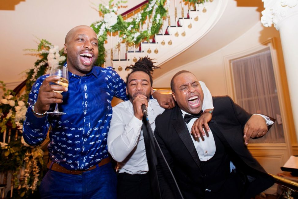 men dance and sing during a reception
