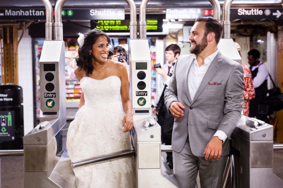 a man and woman walk through subway turnstiles