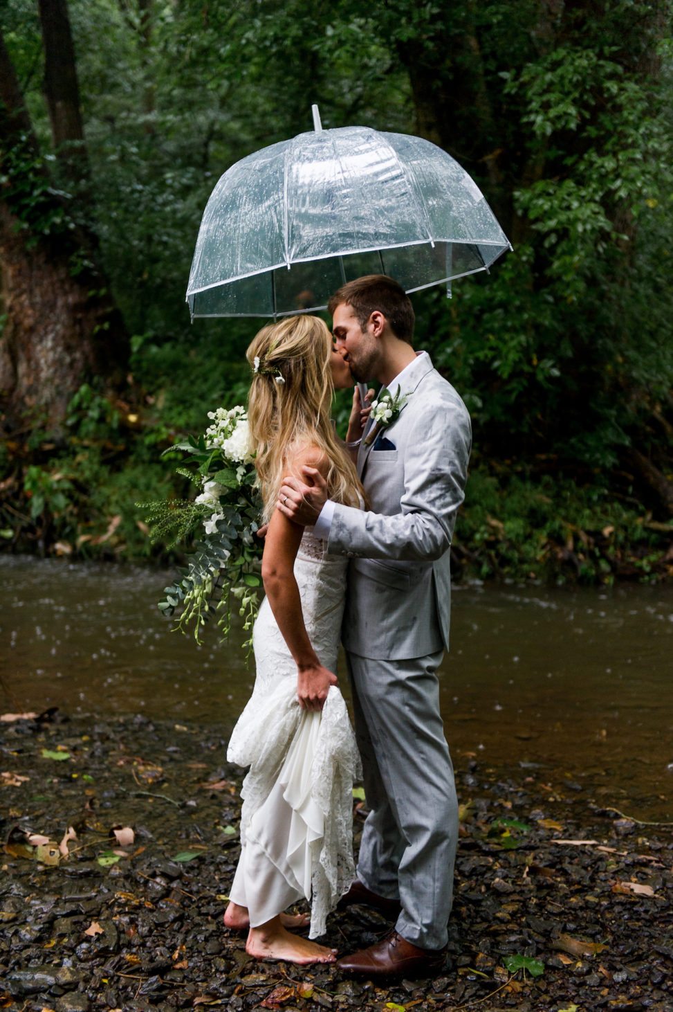 A man and woman kiss in the rain