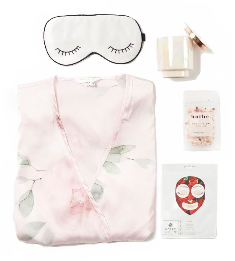 A collection of items including a sleep mask, and pink pajamas